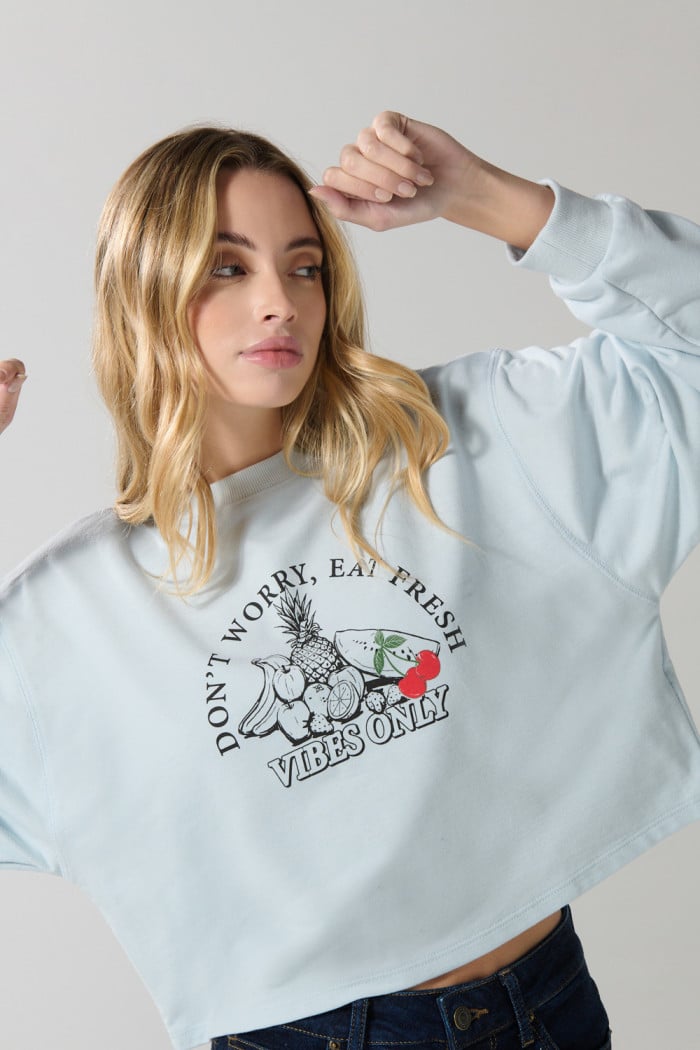 Buzo crop top unicolor con diseño de frutas