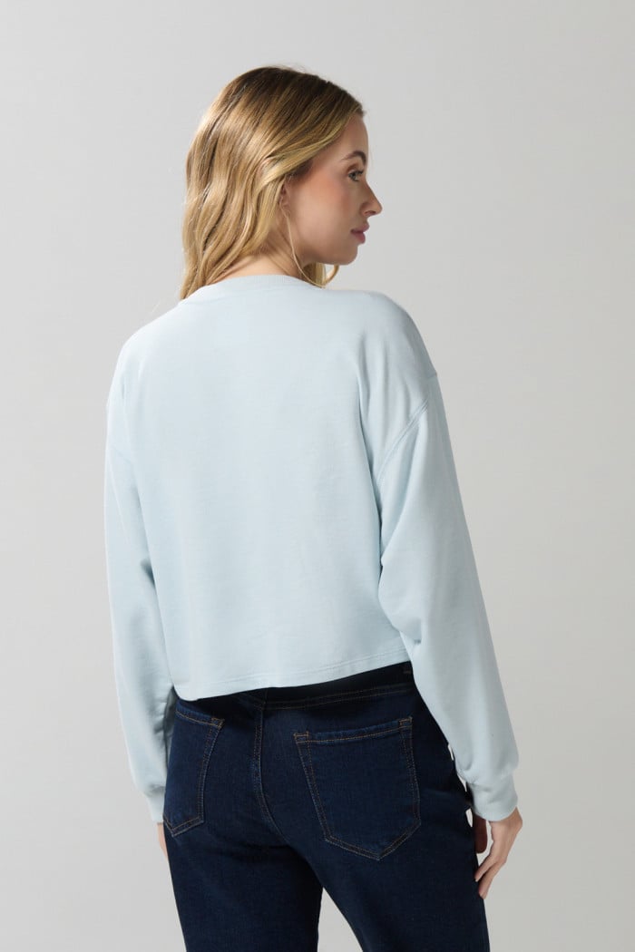 Buzo crop top unicolor con diseño de frutas