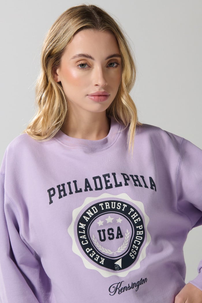 Buzo crop top lila college con cuello redondo
