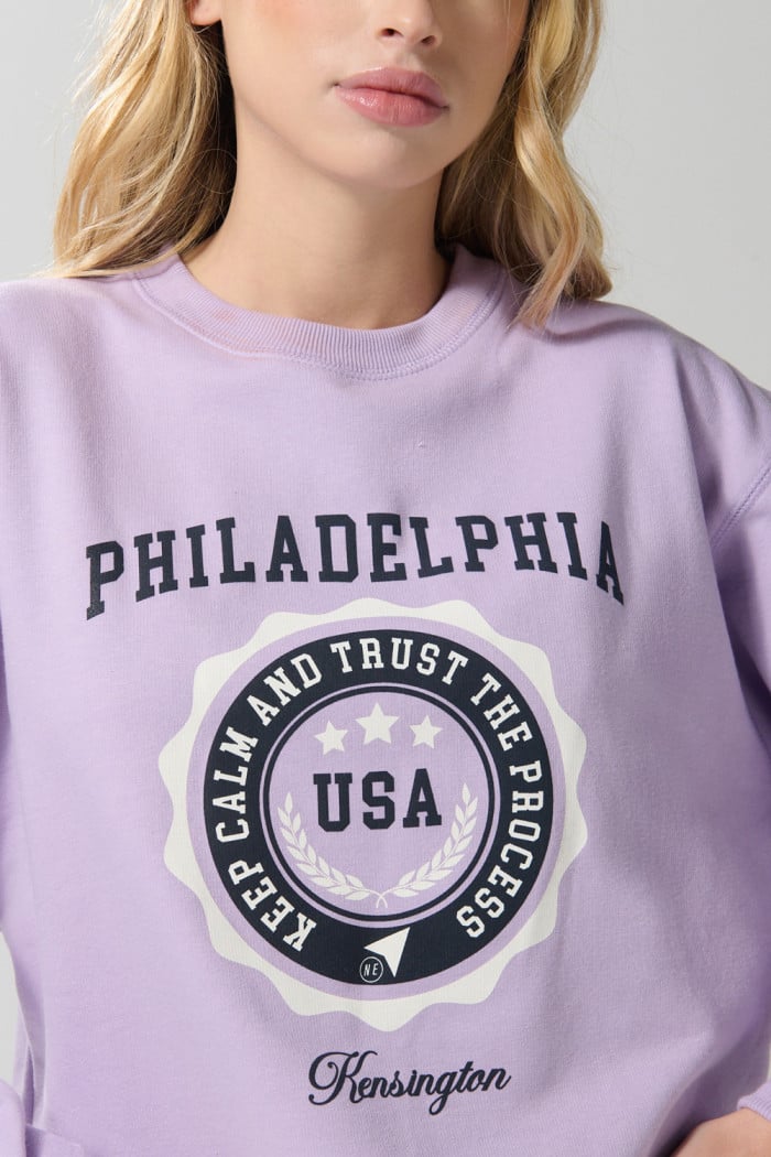 Buzo crop top lila college con cuello redondo