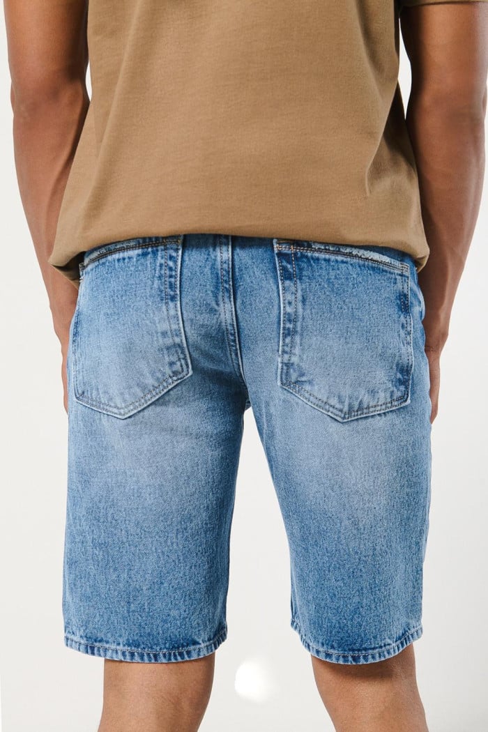 Bermuda azul en jean slim con rotos en frente y tiro bajo