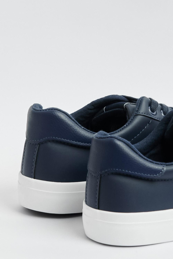Tenis casuales azules oscuros con suelas planas blancas
