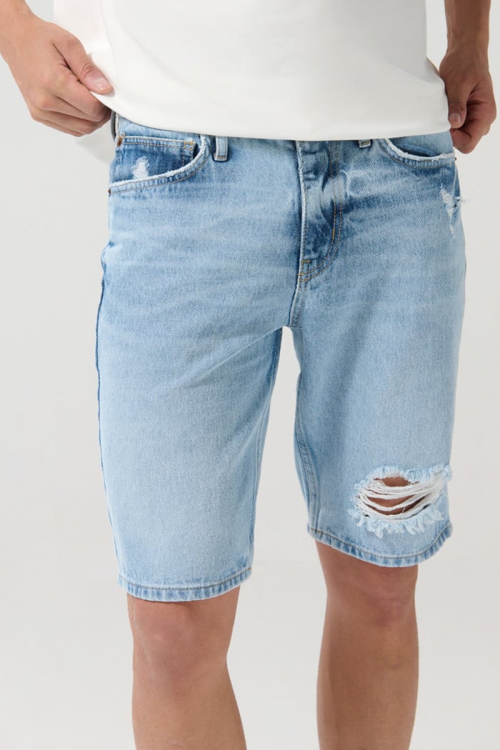 Bermuda en jean slim tiro bajo azul clara con rotos