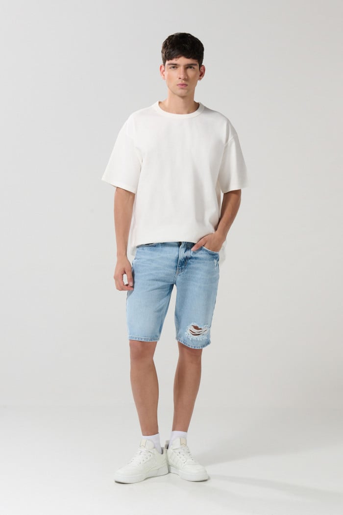 Bermuda en jean slim tiro bajo azul clara con rotos
