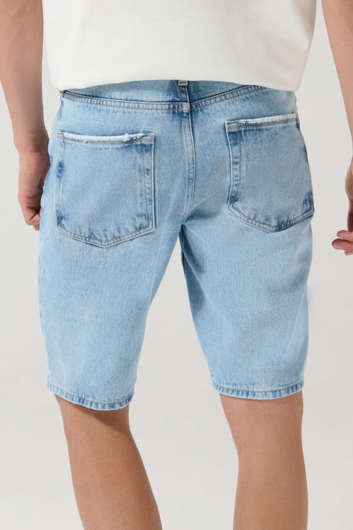 Bermuda en jean slim tiro bajo azul clara con rotos