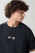 Camiseta negra oversize cuello redondo con arte celestial
