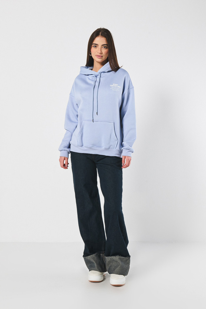 Buzo azul claro oversize con texto minimalista y capota