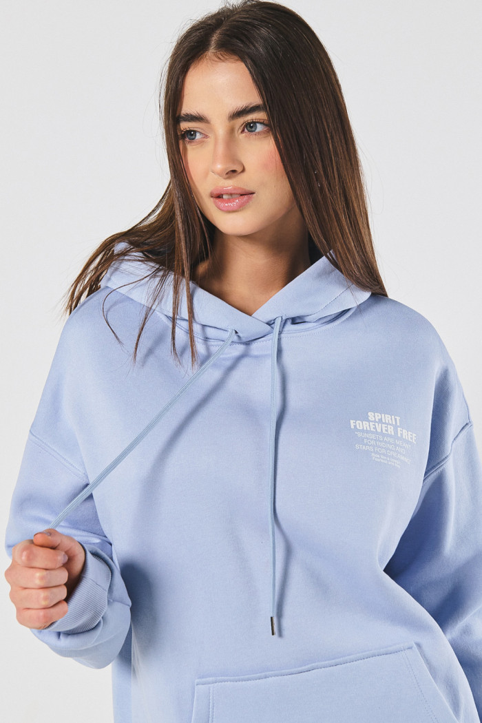 Buzo azul claro oversize con texto minimalista y capota