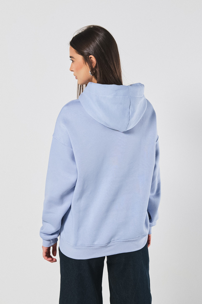 Buzo azul claro oversize con texto minimalista y capota