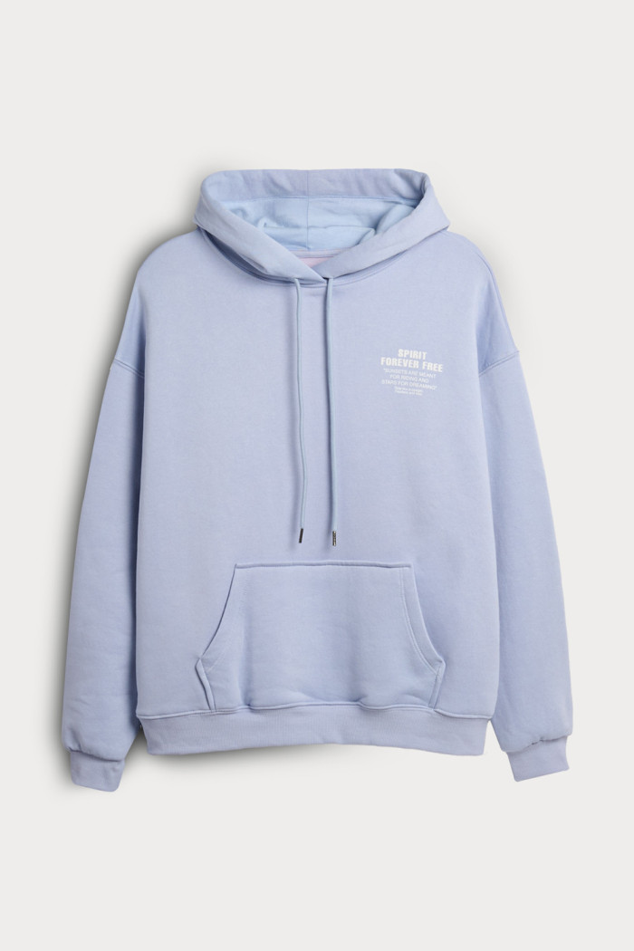 Buzo azul claro oversize con texto minimalista y capota
