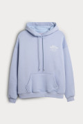 Buzo azul claro oversize con texto minimalista y capota