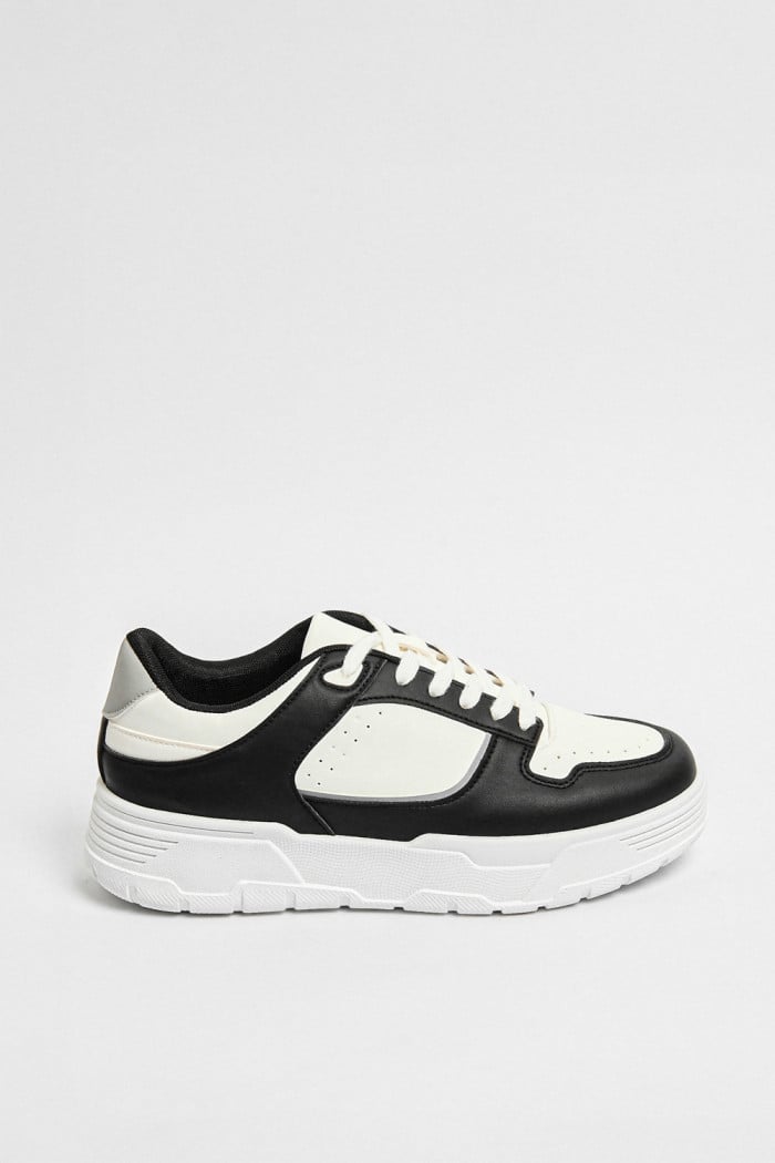 Tenis negros casuales con cortes blancos y suelas livianas