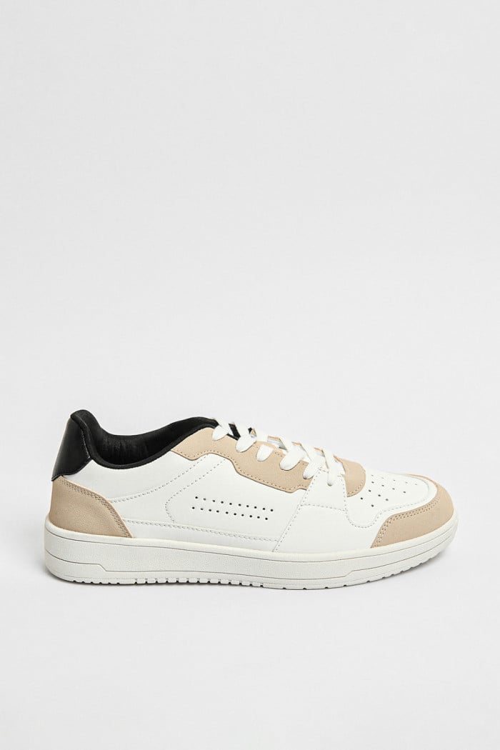 Tenis planos unicolores con perforaciones y contrastes