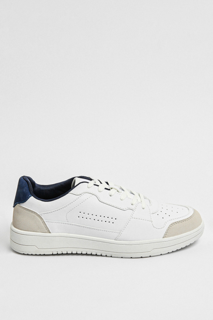 Tenis planos unicolores con perforaciones y contrastes