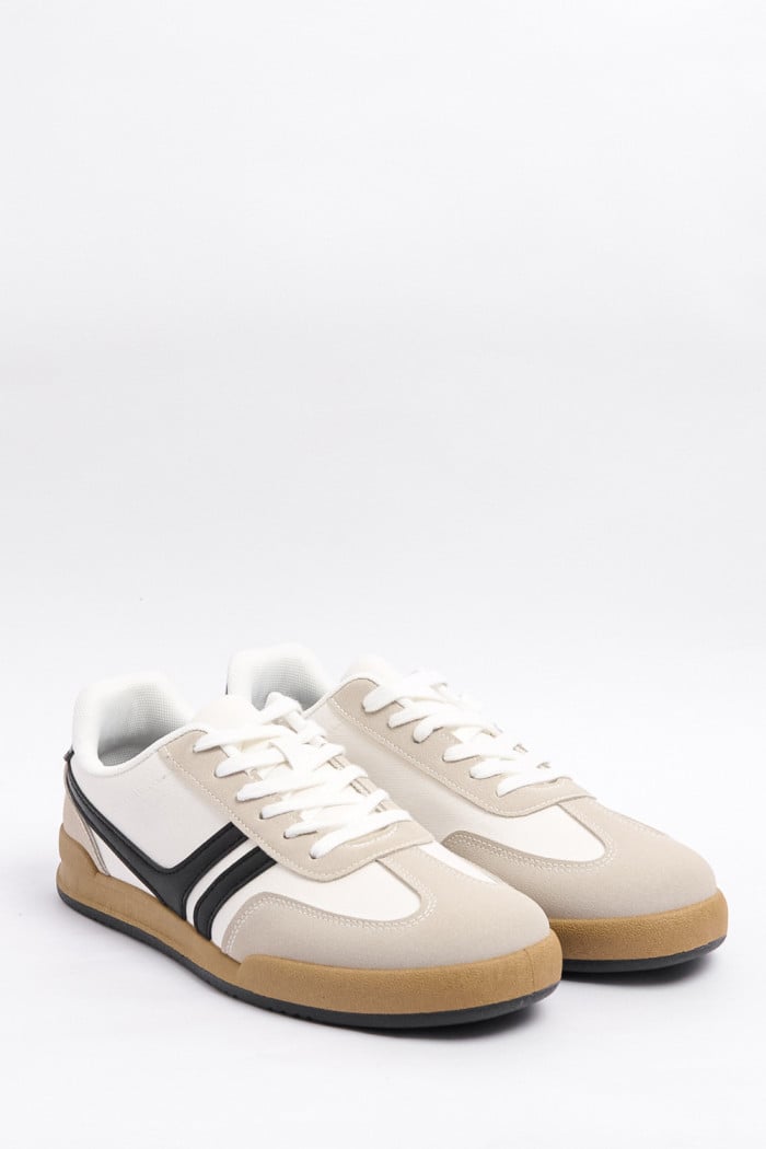 Tenis blancos casuales con franjas negras localizadas