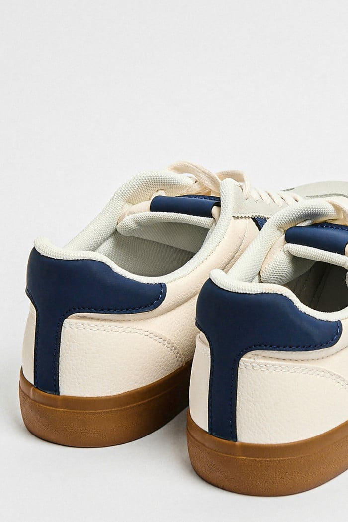 Tenis casuales blancos con contrastes azules localizados