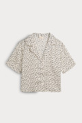 Blusa en satín manga corta unicolor con diseños estampados