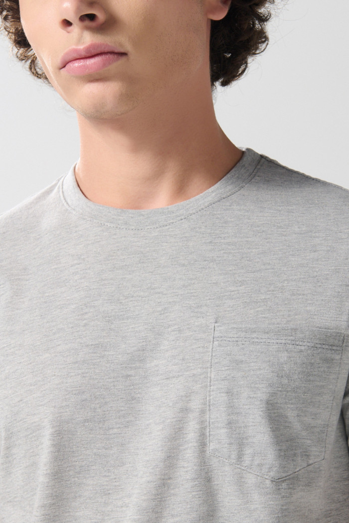 Camiseta gris clara manga corta con bolsillo en frente