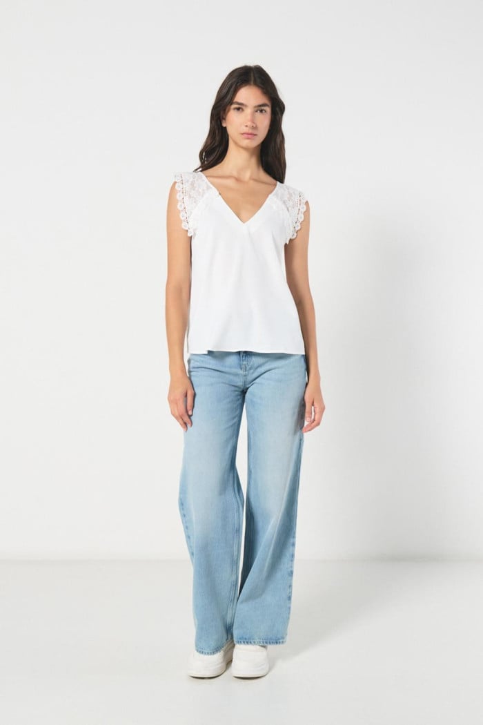Blusa crema clara con escote en V y hombros en encaje
