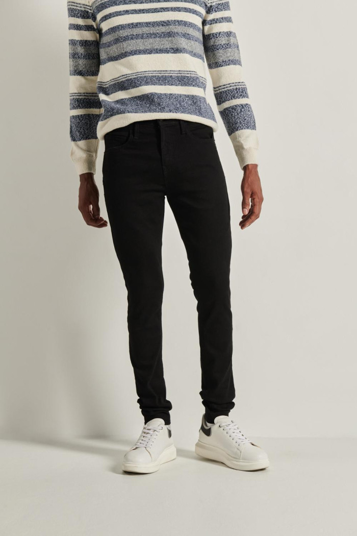 Jean súper skinny ajustado negro con cremallera y tiro bajo