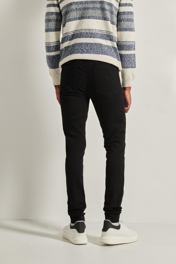 Jean súper skinny ajustado negro con cremallera y tiro bajo