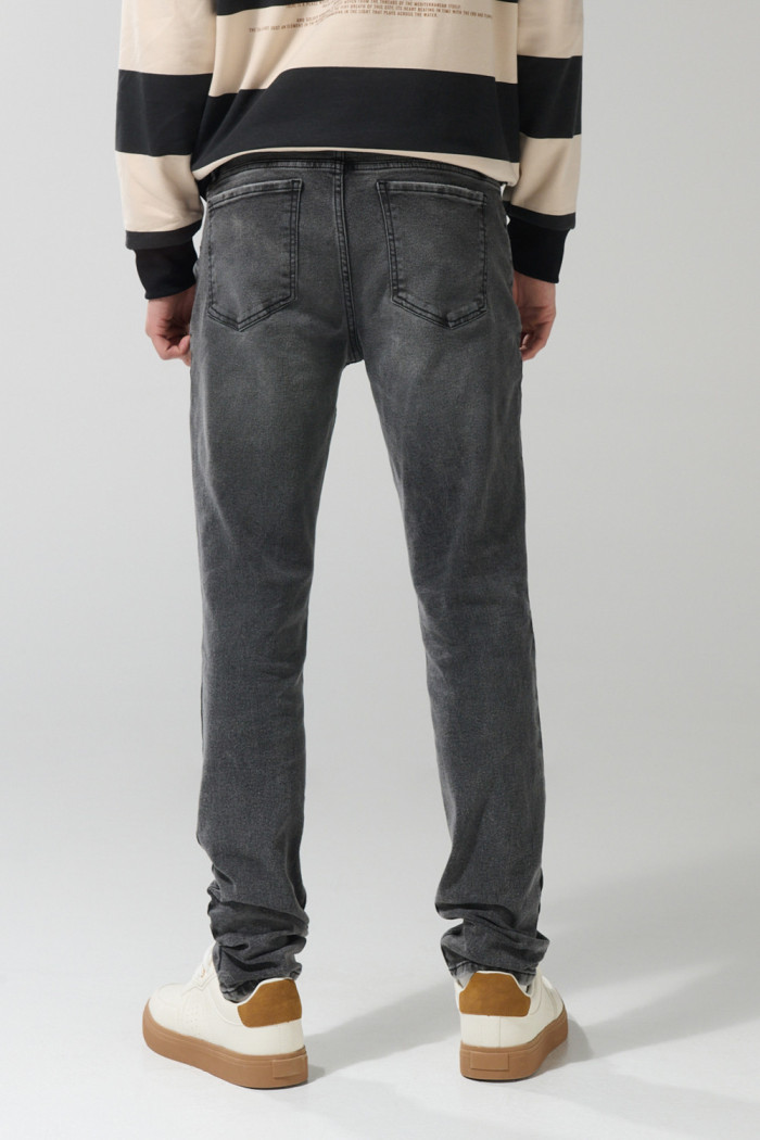 Jean skinny gris oscuro tiro bajo con ligeros desgastes