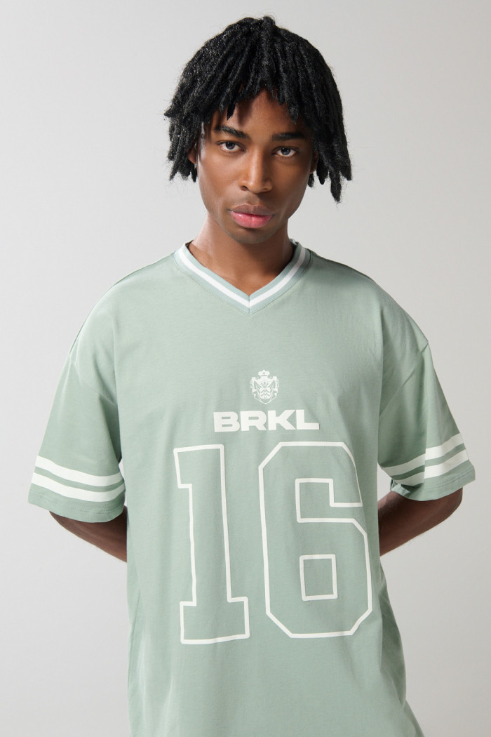 Camiseta cuello V oversize verde clara con diseño college