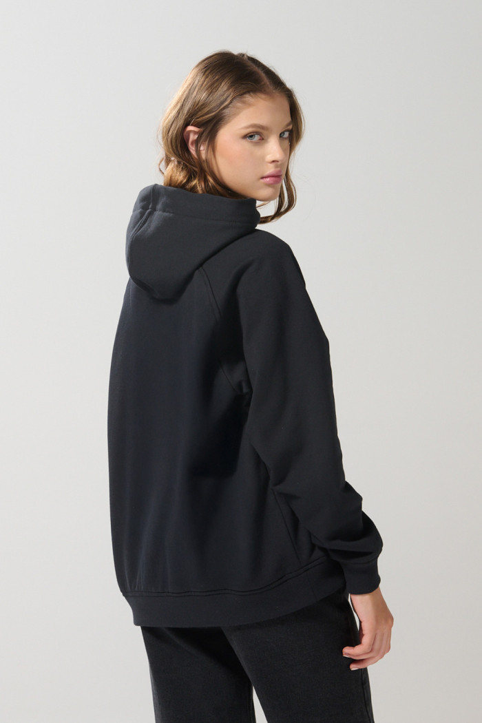 Buzo negro oversize con manga ranglan, capota y cremallera
