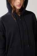Buzo negro oversize con manga ranglan, capota y cremallera