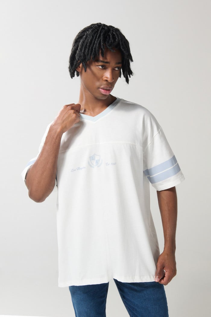 Camiseta crema cuello V con diseño college oversize
