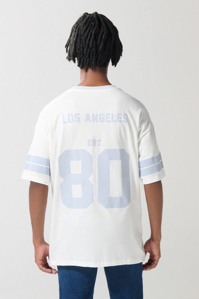 Camiseta crema cuello V con diseño college oversize