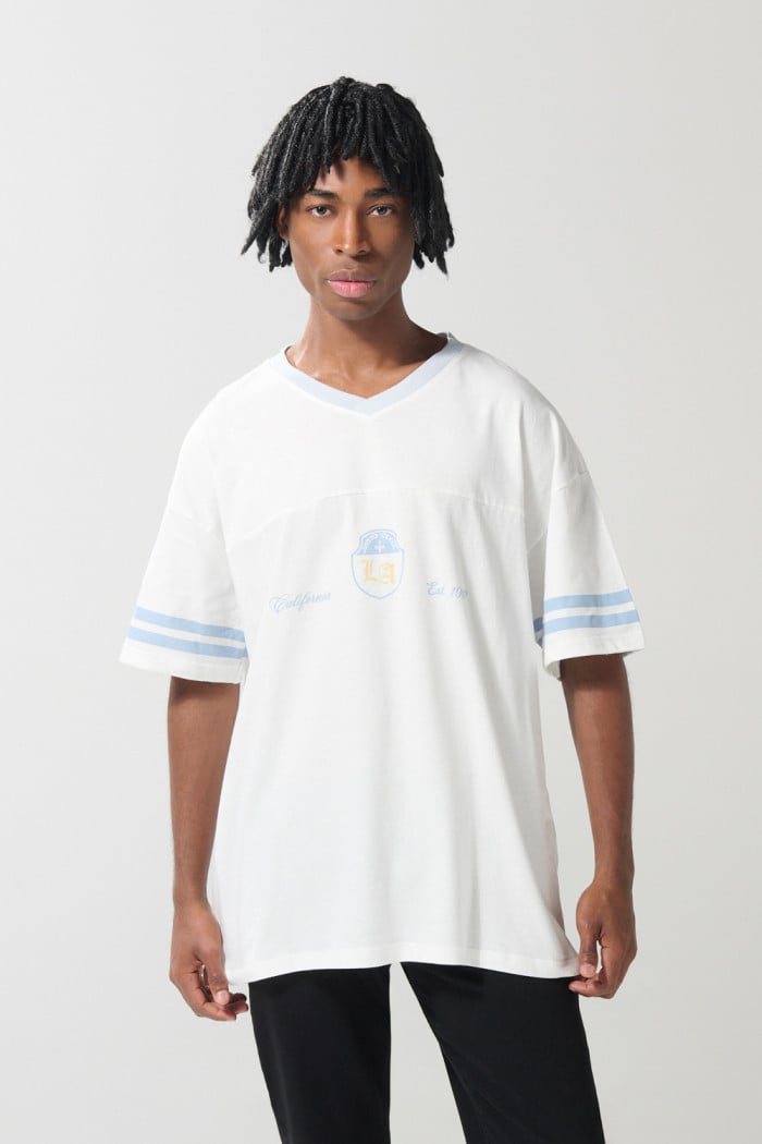Camiseta cuello V crema oversize con diseño college