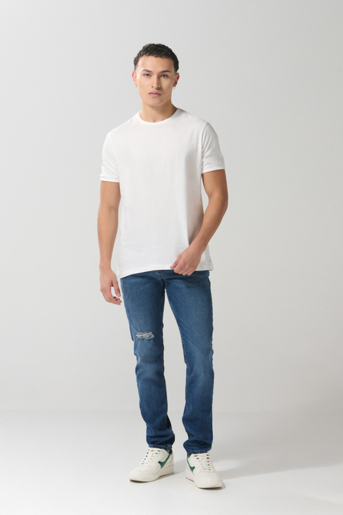 Jean azul oscuro slim con rotos en frente y tiro bajo