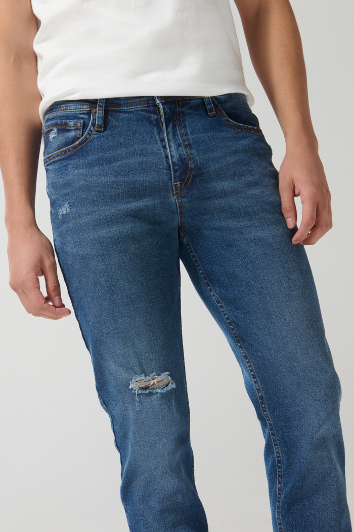 Jean azul oscuro slim con rotos en frente y tiro bajo