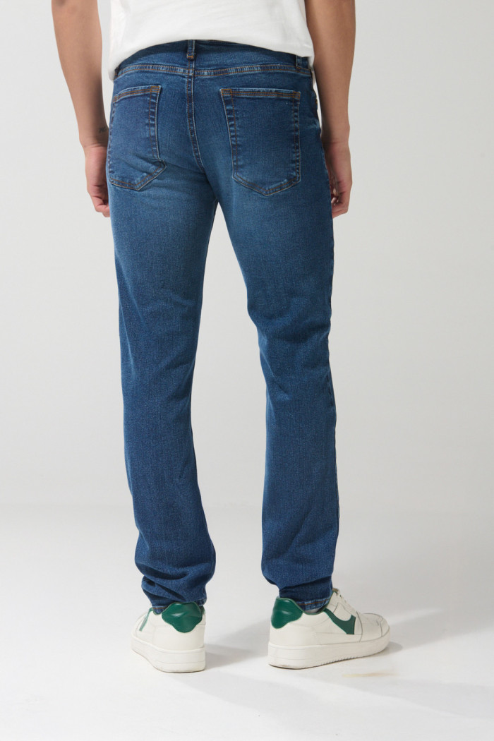 Jean azul oscuro slim con rotos en frente y tiro bajo