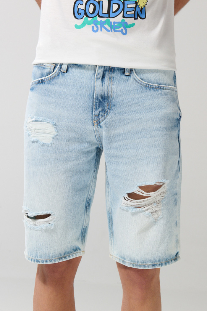 Bermuda tiro bajo en jean slim azul con y rotos en frente