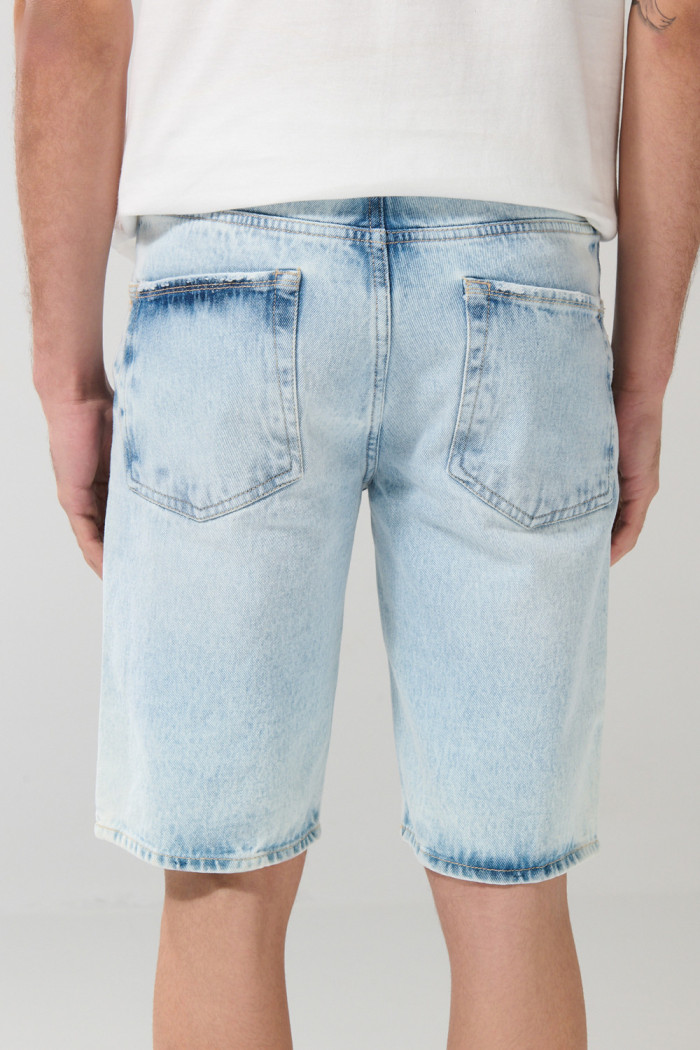 Bermuda tiro bajo en jean slim azul con y rotos en frente
