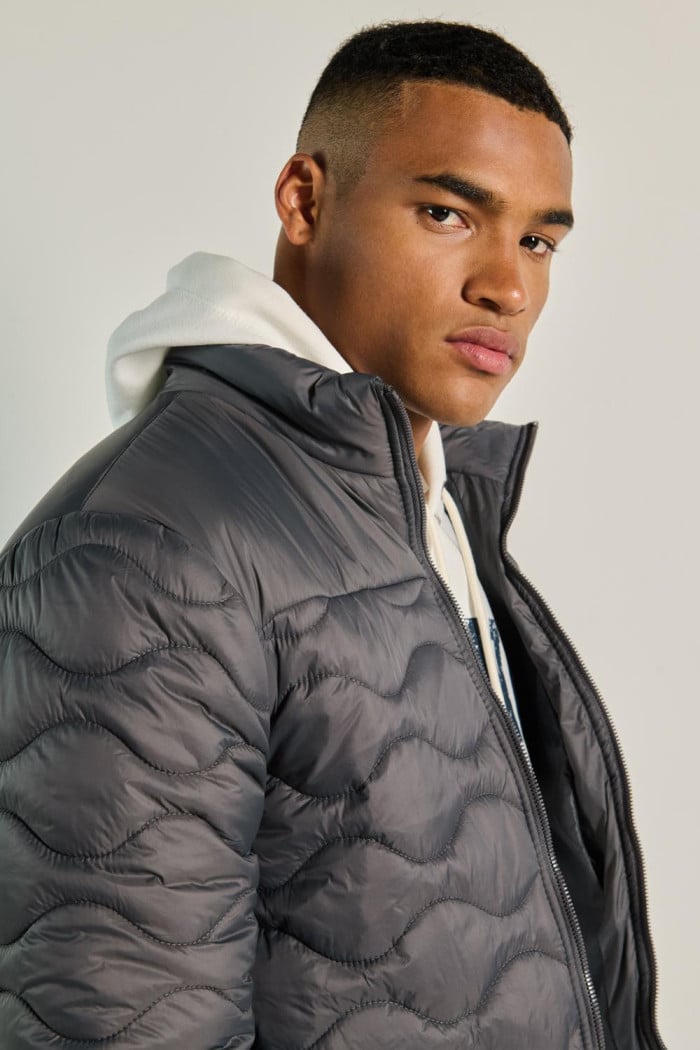 Chaqueta acolchada gris oscura con costuras y cuello alto