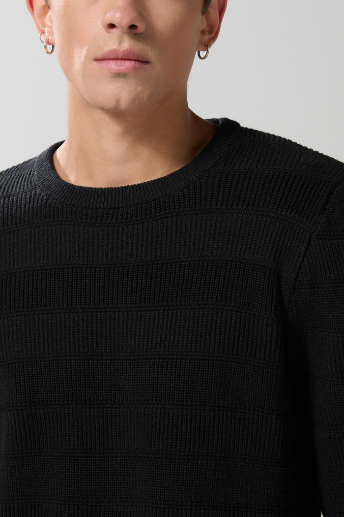 Suéter cuello redondo tejido negro con canales en relieve