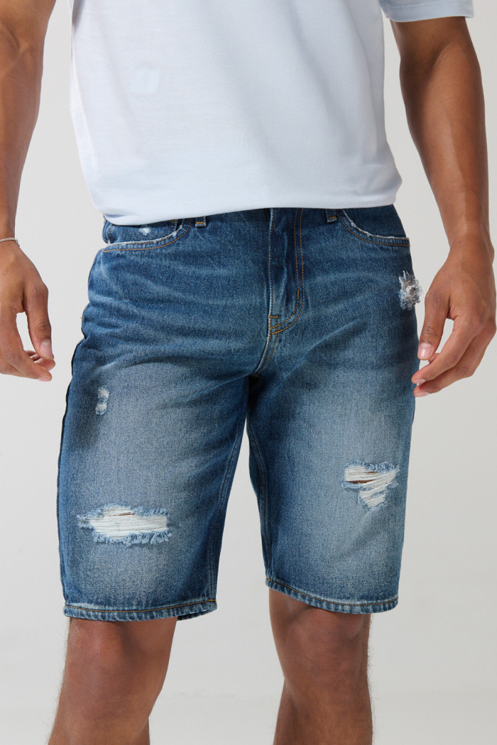 Bermuda slim tiro bajo en jean azul con rotos en frente
