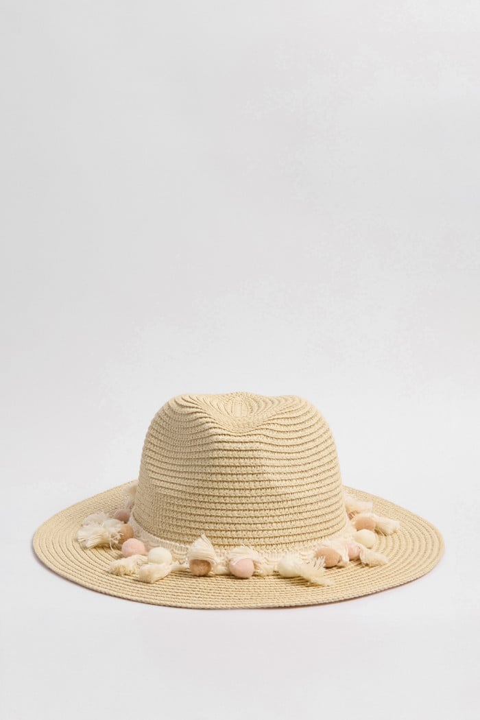 Sombrero fedora en color crema con borlas decorativas en color rosa.