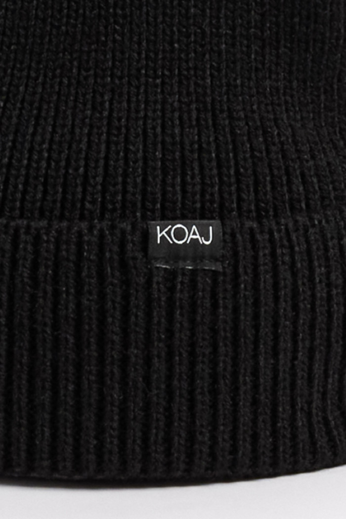 Gorro tejido negro con marquilla decorativa en frente