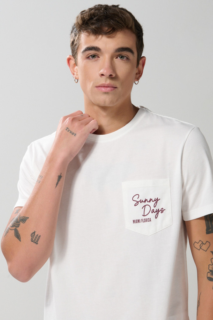 Camiseta unicolor con manga corta, texto y bolsillo