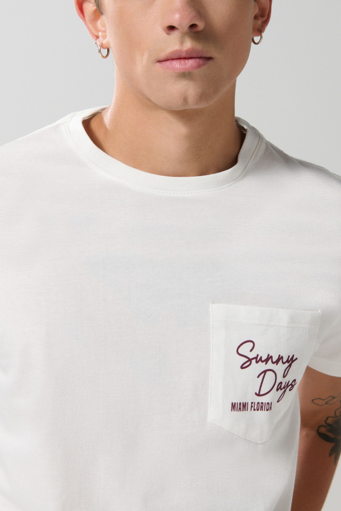 Camiseta unicolor con manga corta, texto y bolsillo