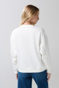 Buzo crema claro con cuello redondo y hombro rodado