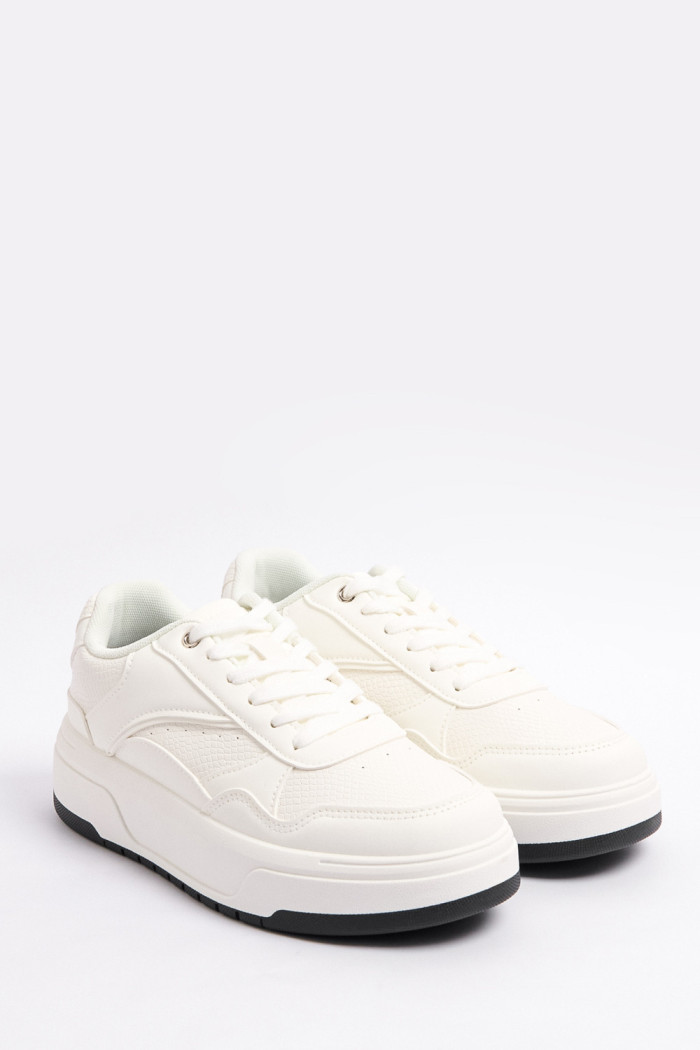 Tenis casuales blancos con texturas y suelas planas