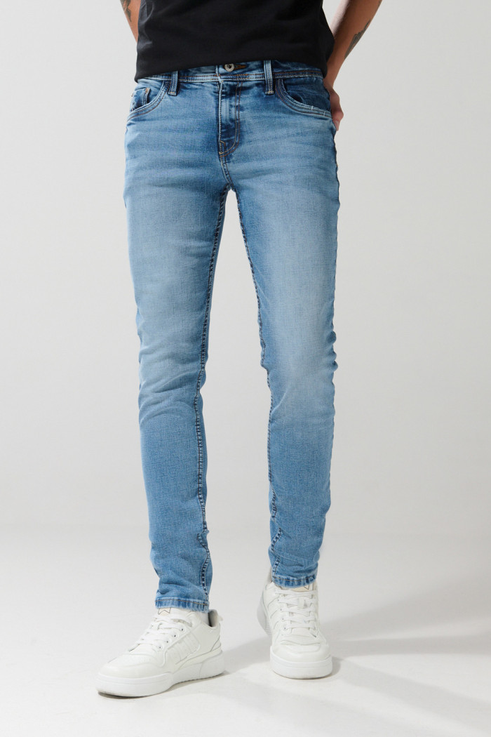 Jean skinny ajustado azul medio con desgastes y tiro bajo
