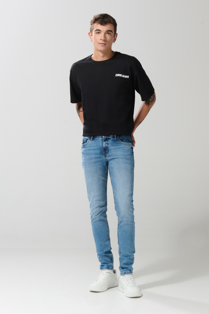 Jean skinny ajustado azul medio con desgastes y tiro bajo