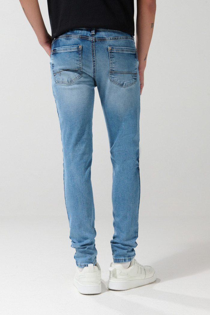 Jean skinny ajustado azul medio con desgastes y tiro bajo