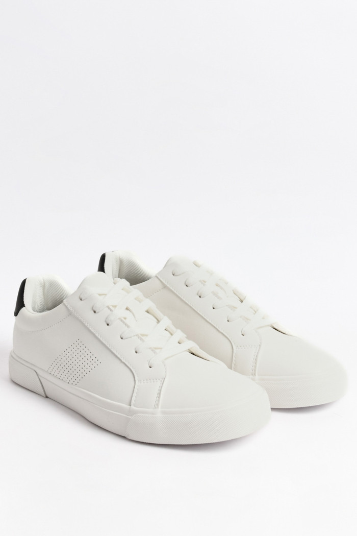 Tenis blancos casuales con contraste negro y perforaciones
